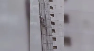 Halatı kopan iskeleden düşmemek için balkona atlayan 2 işçi mahsur kaldı
